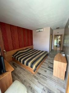 斯利文HOTEL KREDO的一间卧室配有一张床,铺有木地板