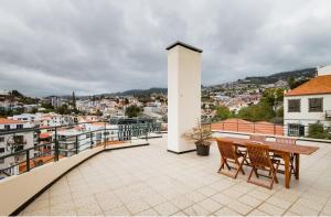 丰沙尔A ver o mar rooms- Funchal city center的阳台的天井配有桌椅