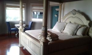 曼德维尔Chateau la Mel的一间卧室配有一张带天蓬的大型白色床