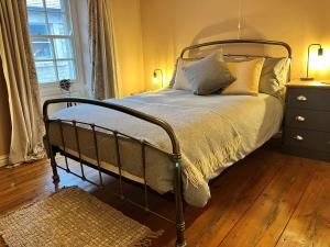 兰卡斯特5 Castle Hill的一间卧室配有一张带金属框架和枕头的床