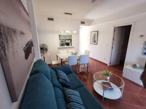 韦尔瓦2 Piscinas en Isla Canela的客厅配有蓝色的沙发和桌子