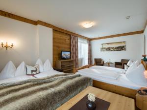 菲根Hotel Landhaus Zillertal的酒店客房设有两张床和电视。
