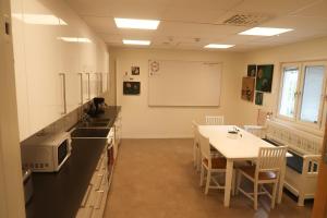 SlädaSkrå hostel - bed & business的配有桌椅和白板的教室