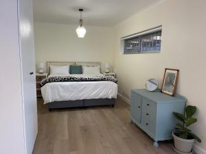 开普敦Silver Sunsets Self-Catering Apartments的一间卧室配有一张床、梳妆台和镜子