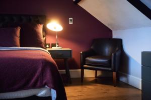 拉恩The Brown's Hotel的一间卧室配有一张床、一把椅子和一盏灯