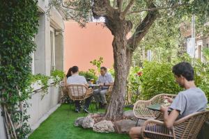 巴塞罗那特雷斯托雷斯阿迪拉姆酒店的一群人坐在树下桌子旁