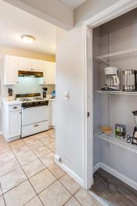 罗切斯特3BR Home with In-Unit Laundry, Parking, Sound Bar的厨房配有白色橱柜和瓷砖地板。
