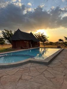 Tsavo West National ParkLake Jipe Eco Lodge的一个带游泳池和小屋的度假村