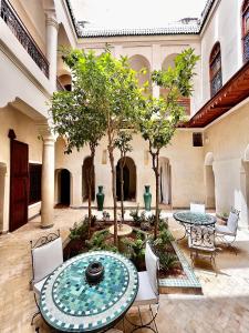 马拉喀什Riad Dar Zaouia的庭院配有桌椅和树木