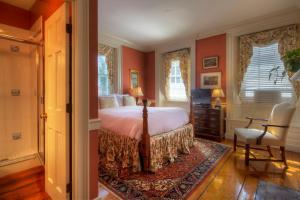 纽波特Francis Malbone House的卧室设有红色的墙壁、一张床和椅子