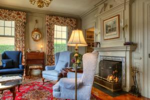 纽波特Francis Malbone House的客厅配有两把椅子和壁炉