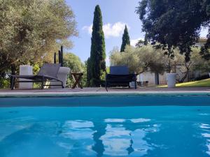 蒙彼利埃Bastide Castella的一个带两把椅子和桌子的游泳池