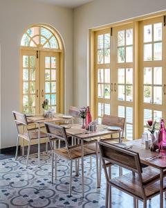布什格尔HOTEL WHITE RABBIT的用餐室设有桌椅和窗户。