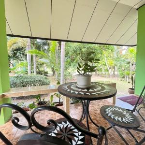 卡农快乐度假村 的一个带桌椅的庭院和一个大窗户。
