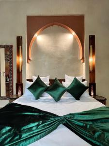 马拉喀什Riad Dar Zaouia的一间卧室配有一张带绿色枕头的大床