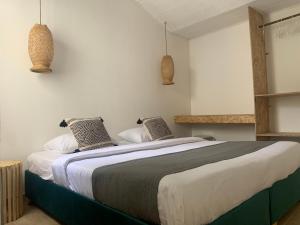 波哥大Hotel Quintas de Normandia的一间卧室配有一张大床和两个枕头