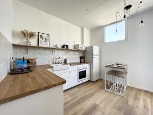 马赛Charmant appartement rénové - Central & Spacieux - Les Frères de la Loc'的厨房配有白色橱柜和冰箱。