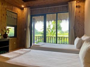 宁平Mường Village Ninh Bình的一间卧室设有一张床和一个大窗户