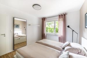 罗特威尔City-Luxus Apartment Rottweil的白色的客房配有镜子和床