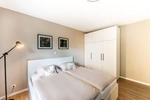 罗特威尔City-Luxus Apartment Rottweil的一间卧室配有床和白色橱柜
