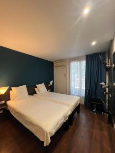 佩皮尼昂B&B HOTEL Perpignan Centre的一间卧室配有一张白色大床和蓝色的墙壁