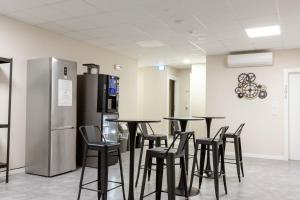 阿尔盖罗Piccolo Catalunya Hostel的客房设有桌椅和冰箱。