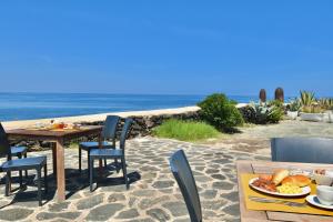 潘泰莱里亚Cossyra Hotel的海滩上一张桌子和一盘食物