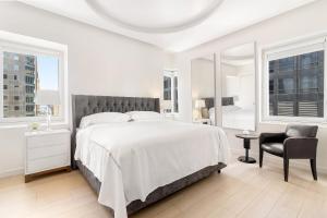 纽约Luxury Midtown West 4 Bedroom Apartment Near Radio City的白色卧室配有一张大床和椅子
