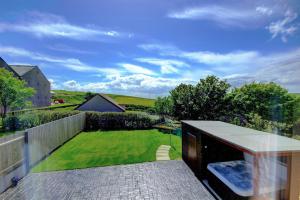 奥克尼Aurora - Self Catering, Kirkwall, Quiet Location with Luxury Hot Tub的阳台享有花园景色。
