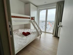 米德尔克尔克Gezinsappartement in Middelkerke - Noort-C的一间卧室设有一张双层床和大窗户。
