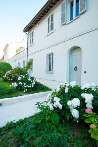 拉文纳Au petit jardin的白色房子前面有白色的花