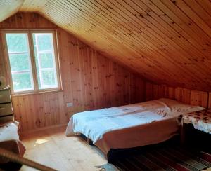 GinučiųLakefront Log House and Sauna的木制阁楼卧室配有一张床