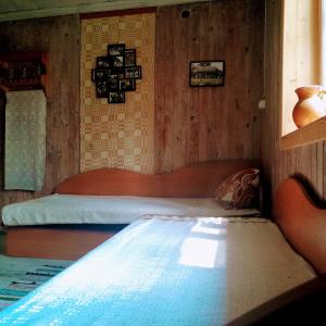 GinučiųLakefront Log House and Sauna的木制客房内的一间卧室,配有一张床