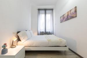 米兰Espinasse Apartment的白色的卧室设有床和窗户