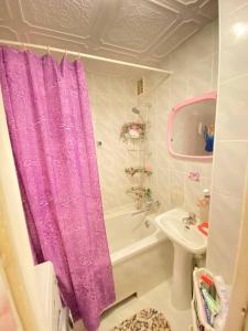 尤尔马拉Комната с лоджией у Татьяны的浴室设有紫色的浴帘和水槽