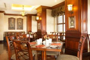 基多广场大酒店的一间带木桌和椅子的用餐室