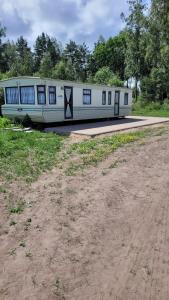 ZiemupeDvēseles veldzes dārzs的停在土路旁的一辆白色火车车厢