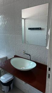 图托亚Pousada Mar & Sol的一间带水槽、卫生间和镜子的浴室