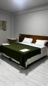 图托亚Pousada Mar & Sol的一间卧室配有一张带绿毯的大床