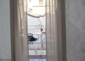 马蒂纳塔Meridiana case al mare centro的窗户享有带桌子的阳台的景致