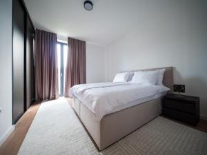 萨拉热窝Villa AURORA的白色的卧室设有一张大床和一个窗户