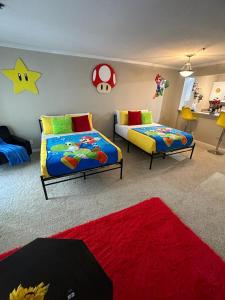 洛杉矶Súper Mario Universal Studios 10 min Loft Free parking的一间带两张床的卧室和红色地毯