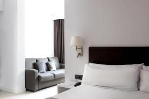 巴塞罗那加泰罗尼亚阿尔贝尼兹酒店的酒店客房,配有床和沙发