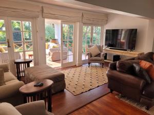 约翰内斯堡Eden Guesthouse的客厅配有家具和平面电视。