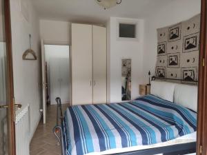 拉科纳CASA LACONA的一间卧室配有一张带蓝白条纹毯子的床