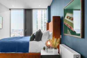 伯明翰The Mercian Luxury Apartments Birmingham City Centre - Your Perfect Stay Apart hotels- 24 Hour Gym Rooftop Terrace Cinema Room的一间卧室设有一张床和蓝色的墙壁