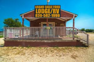 NixonGrand Eagle Ford Lodge & RV Park的一座建筑,上面有标志,上面有宏伟的鹰食亭
