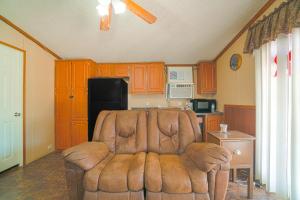 NixonGrand Eagle Ford Lodge & RV Park的客厅设有厨房,配有棕色沙发