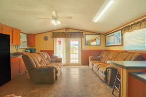 NixonGrand Eagle Ford Lodge & RV Park的一间带棕色真皮沙发的客厅和一间厨房