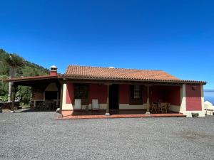 马佐Casa Los Calderos的红色和白色的房子,配有桌子和椅子
